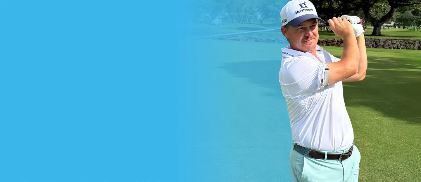 Bud Cauley Swinging golf club wearing a Northmarq hat
