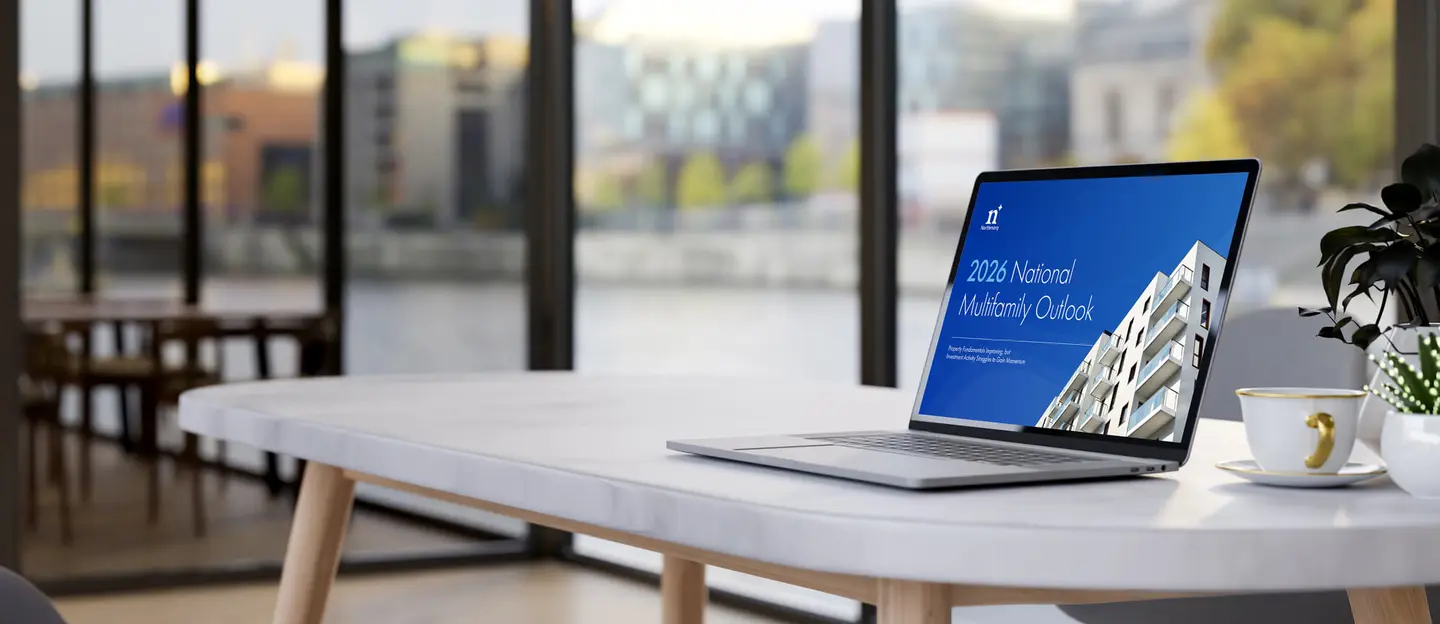 laptop on a desk showing the 2026 midyear multifamily report on the screen