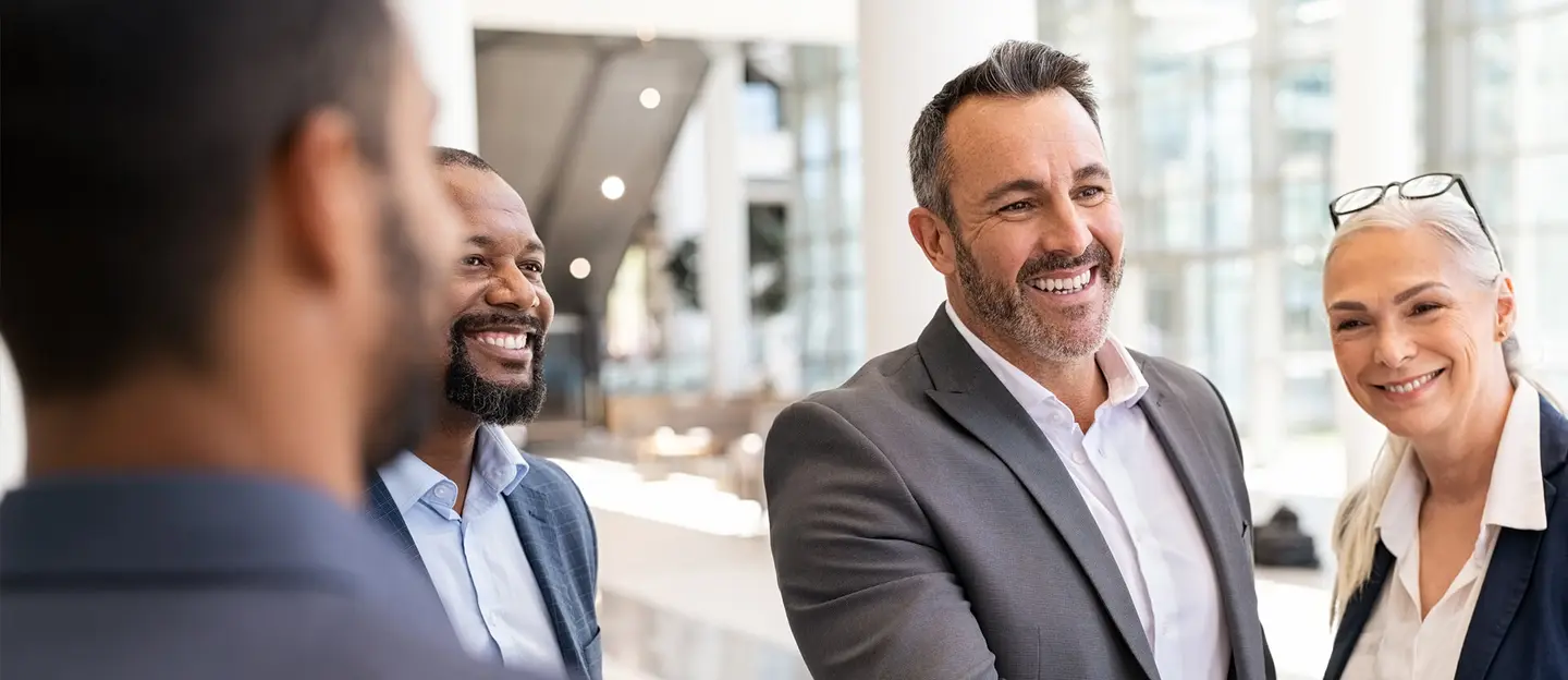 4 smiling people in office setting