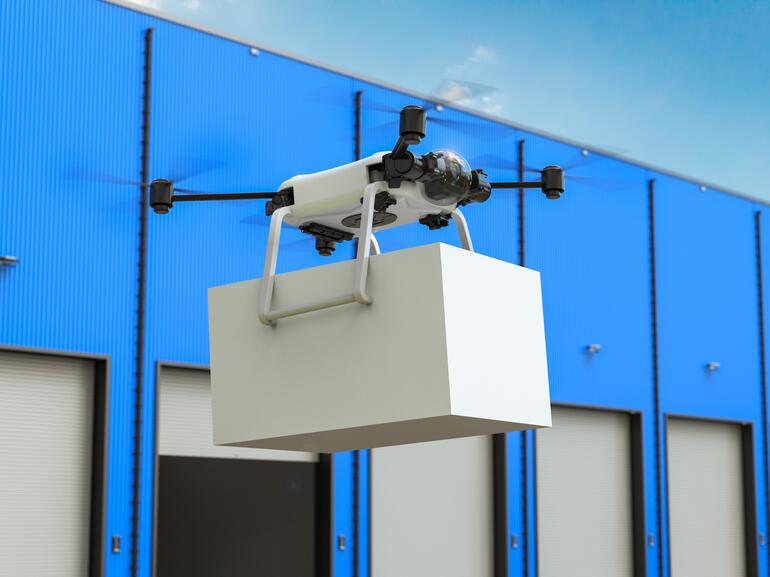 Photo of drone in front of blue warehouse