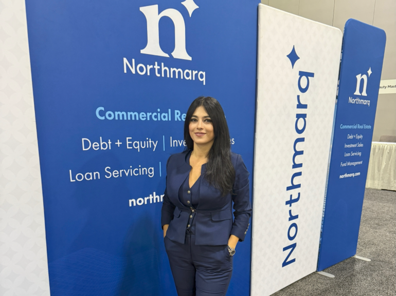 Photo of Ani Paulson in front of Northmarq logo.
