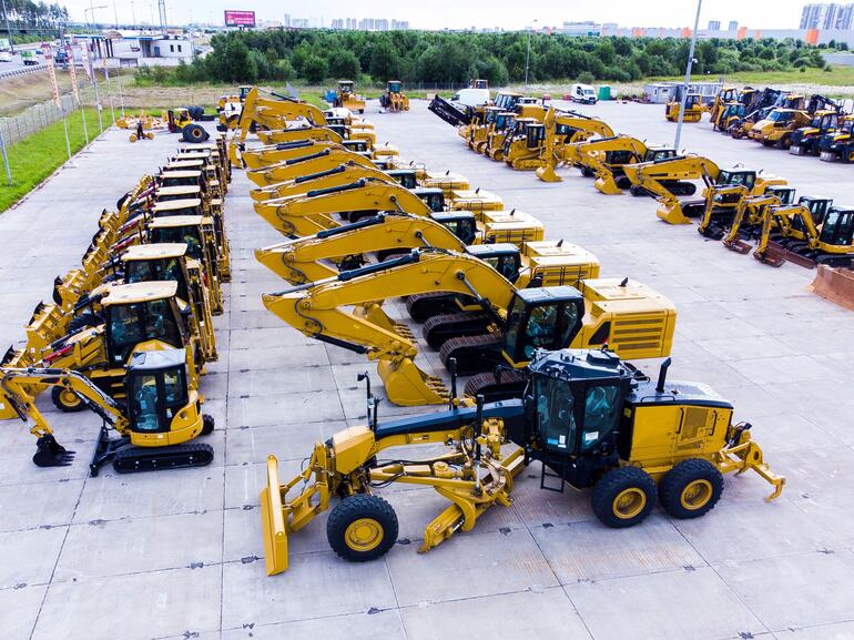 Heavy equipment stored in fenced industrial site