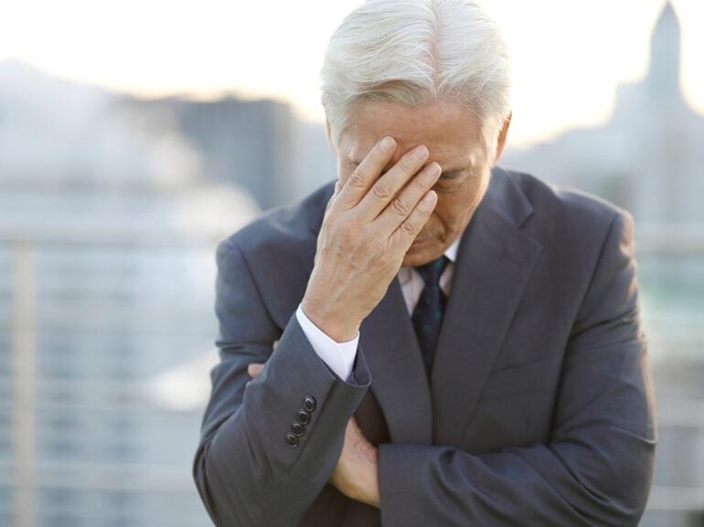 Man places his hand on his head in frustration.