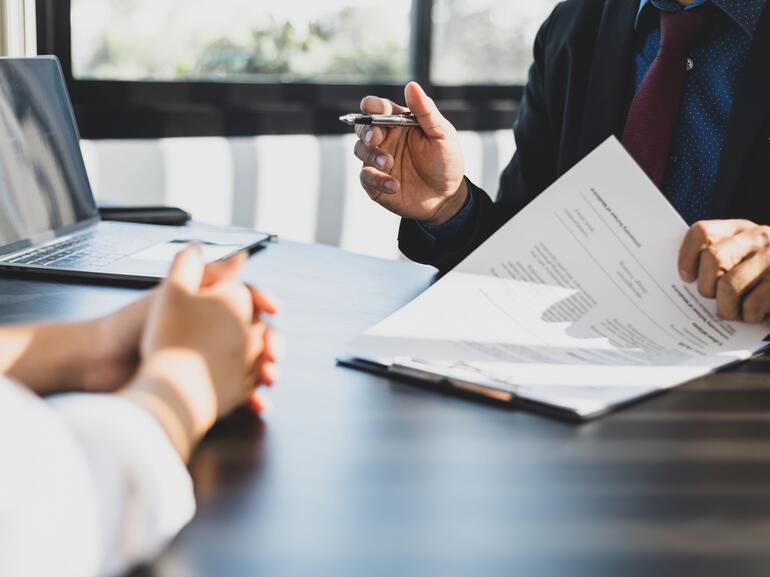 Financing expert shows client paperwork for refinancing using senior stretch loan