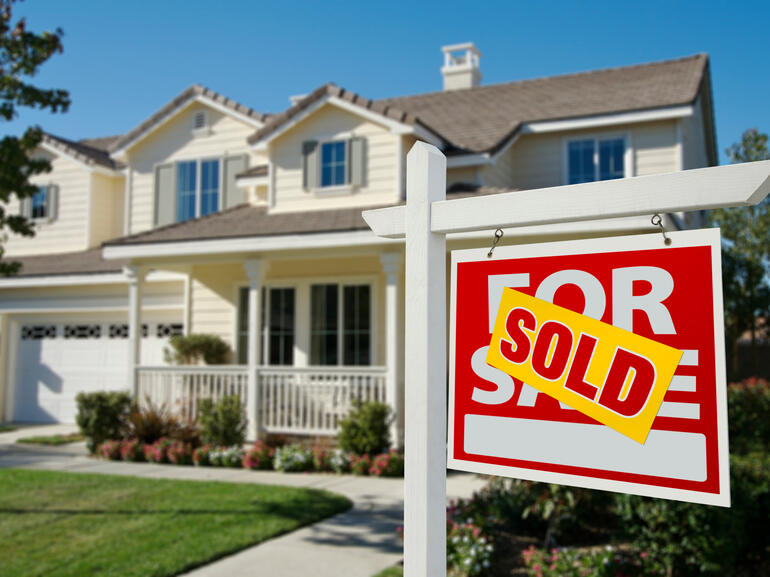 Single family, two-story home with sold sign out front