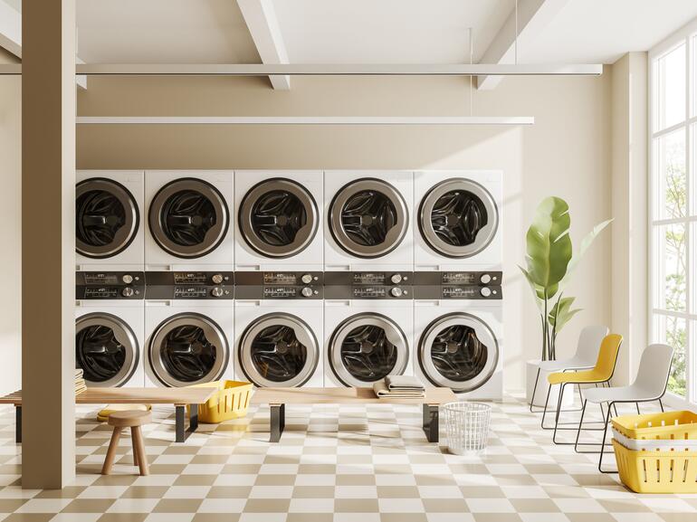 Light laundry interior with row of washing machines and panoramic window