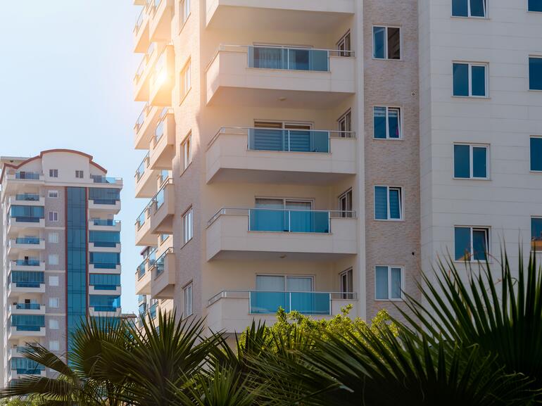 Newly built, multi-story apartment buildings with sun shining
