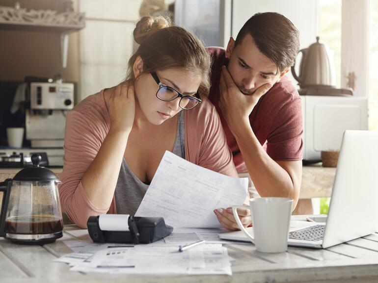 Woman and man looking concerned about bills and finances