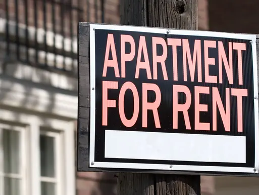 Apartment for rent sign hanging on wooden electrical pole