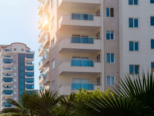 Newly built, multi-story apartment buildings with sun shining
