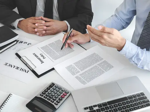 Insurance specialist reviewing policy documents with client